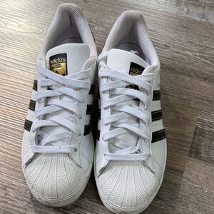 Adidas White Sneakers with Black Stripes and Gold Accents
